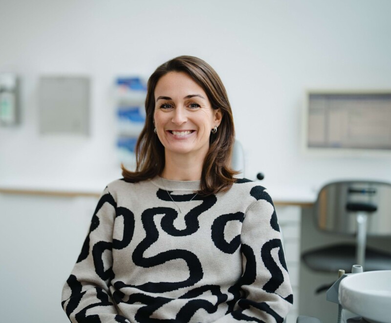 Patientin der Oralchirurgie in der Praxis bei Kitzingen l&auml;chelt in die Kamera.