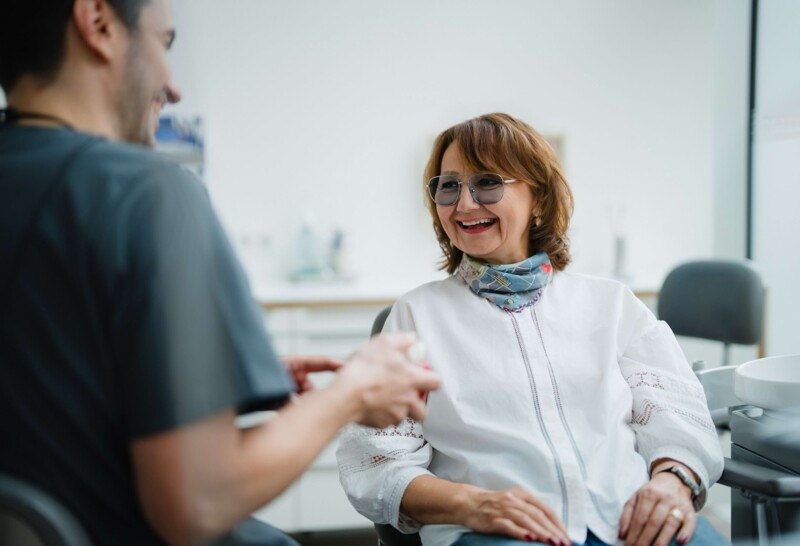 Zahnarzt ber&auml;t Patientin vor dem Eingriff in der Oralchirurgie in der Praxis bei Kitzingen.