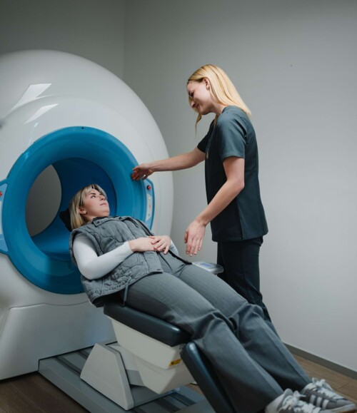 Eine Assistentin begleitet eine Patientin beim Scan Ihres Kiefers mittels moderner Technologie