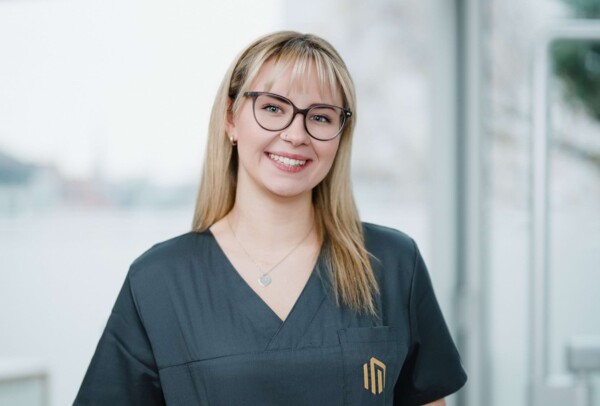 Portrait einer jungen Assistentin, die in die Kamera l&auml;chelt.