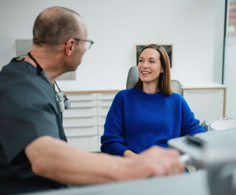 Kieferchirurg spricht mit Patientin der Praxis in W&uuml;rzburg.