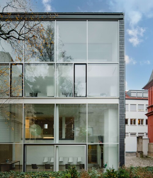 Detailaufnahme des Praxisgeb&auml;udes mit Fokus auf die Glasfassade