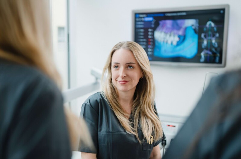 Eine Assistentin der Praxis im Austausch mit einer Patientin