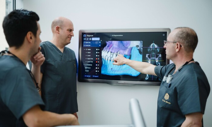 Die Behandler der Praxis beraten sich zu einem anstehenden Eingriff, w&auml;hrend sie ein 3D-Scan analysieren
