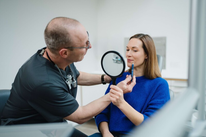 Der Arzt markiert die Stellen im Gesicht der Patientin, die behandelt werden sollen.