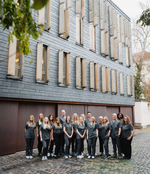Gruppenfoto des gesamten Teams vor dem Praxisgeb&auml;ude