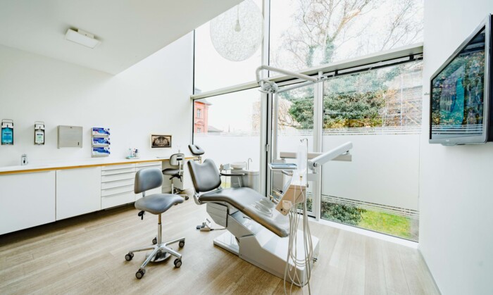 Blick auf eines der vielen modernen und gem&uuml;tlichen Behandlungszimmer der Praxisklinik mit Fensterfront