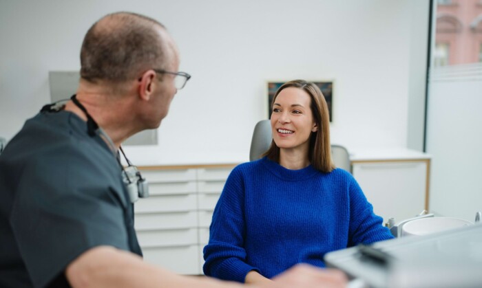 Freundliche Beratung einer Patientin in hellem und modernen Behandlungszimmer