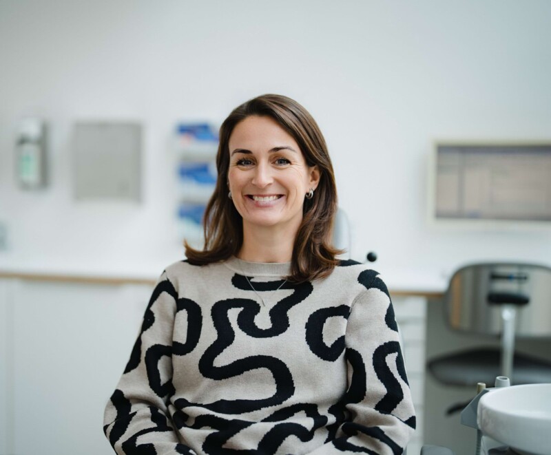 Patientin in der Kieferchirurgie aus Kitzingen l&auml;chelt in die Kamera.