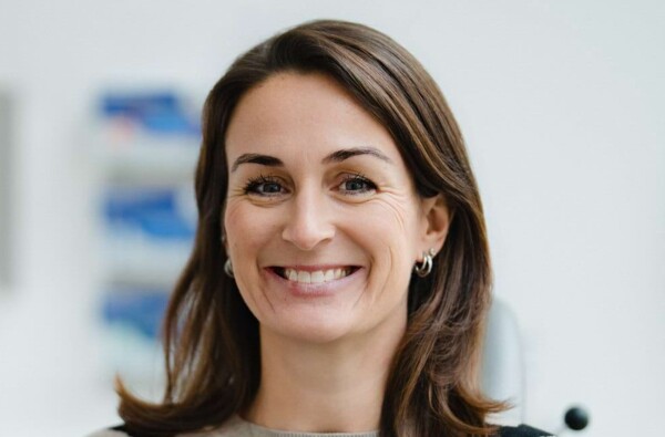 Portrait einer l&auml;chelnden Patientin, die auf dem Behandlungsstuhl sitzt.