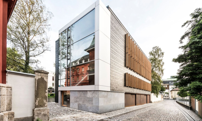 Au&szlig;enaufnahme des architektonisch wertvollen Praixsklinik-Geb&auml;udes. Moderner, kunistischer Bau mit verschiedenen Baustoffen. Viel Stein, Glas, Schiefer und Kortenstahl.